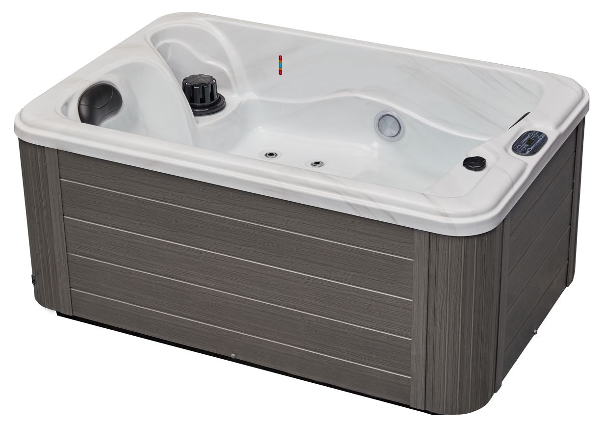 Luxury Spas cashmere hot tub for two with sleek design and soft curves, surrounded by a serene outdoor setting.