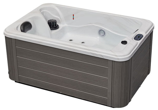 Luxury Spas cashmere hot tub for two with sleek design and soft curves, surrounded by a serene outdoor setting.