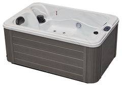 Luxury Spas cashmere hot tub for two with sleek design and soft curves, surrounded by a serene outdoor setting.