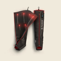 Black and red heated leg sleeves with visible branding on a beige background