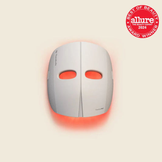 Facial mask with red lights on a beige background, featuring the Allure Best of Beauty 2024 award.
