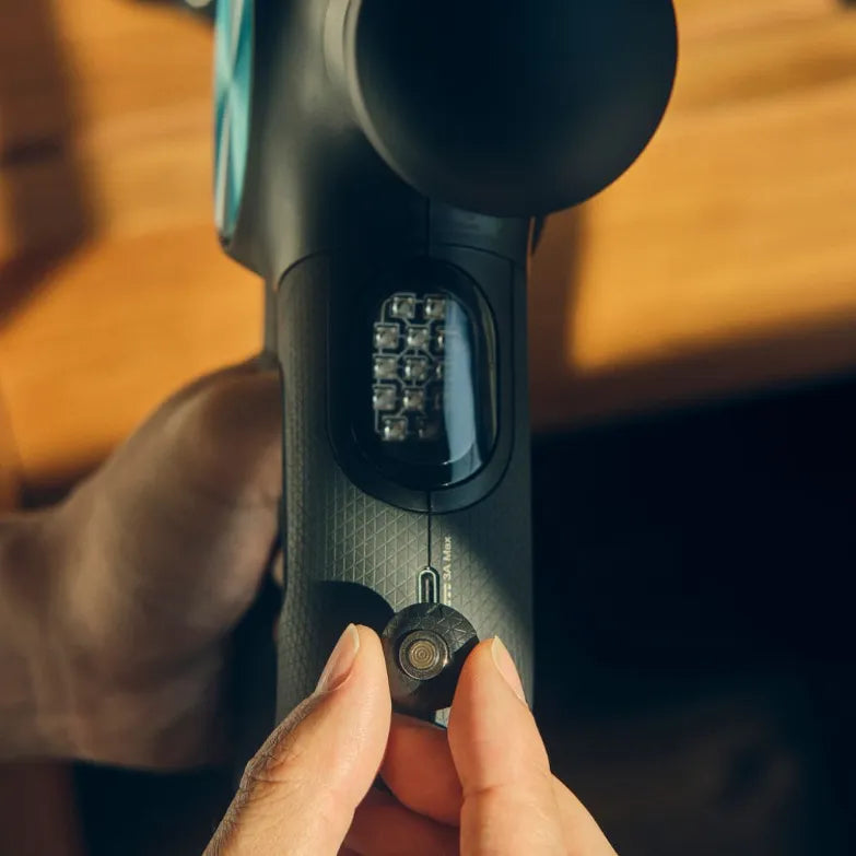 Close-up of a hand holding a theragun pro plus with a focus on the switch.